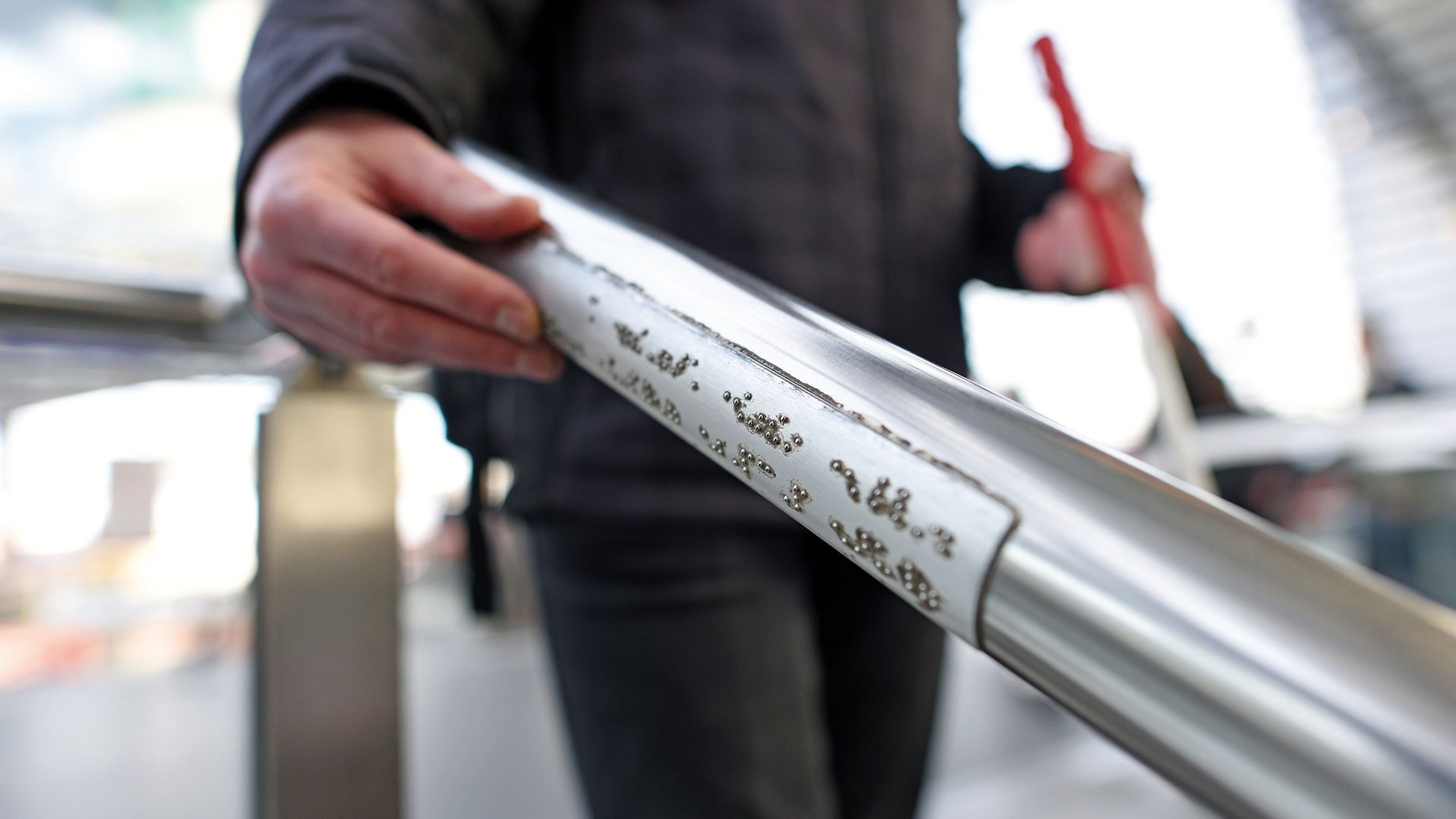 Taktile Handlaufschilder helfen blinden und sehbehinderten Reisenden bei der Orientierung am Bahnhof.