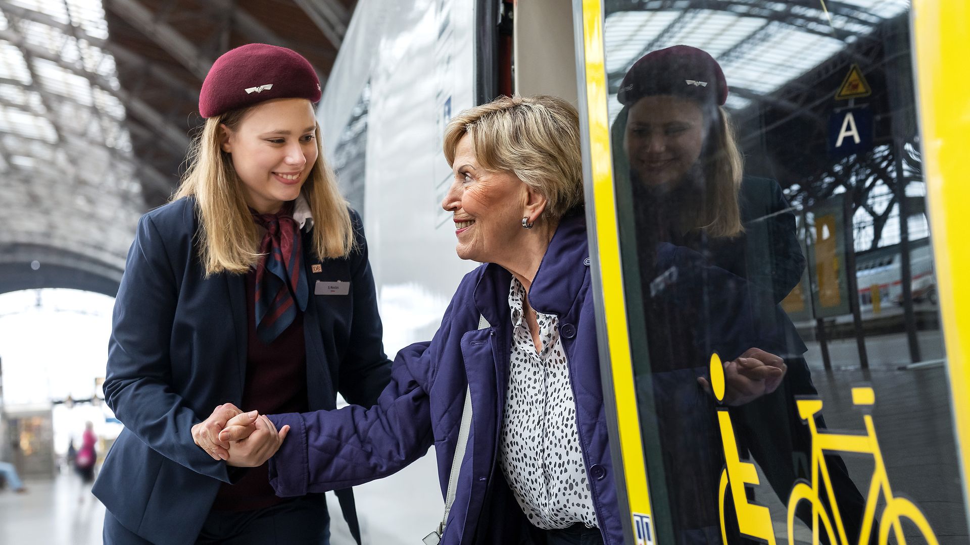 Servicemitarbeitende an Bahnhöfen helfen beim Ein- und Aussteigen.