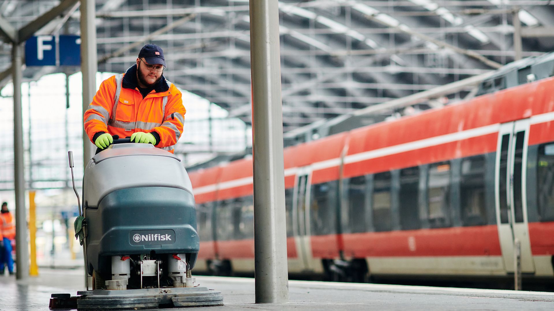 DB-Mitarbeiter reinigt den Bahnsteig