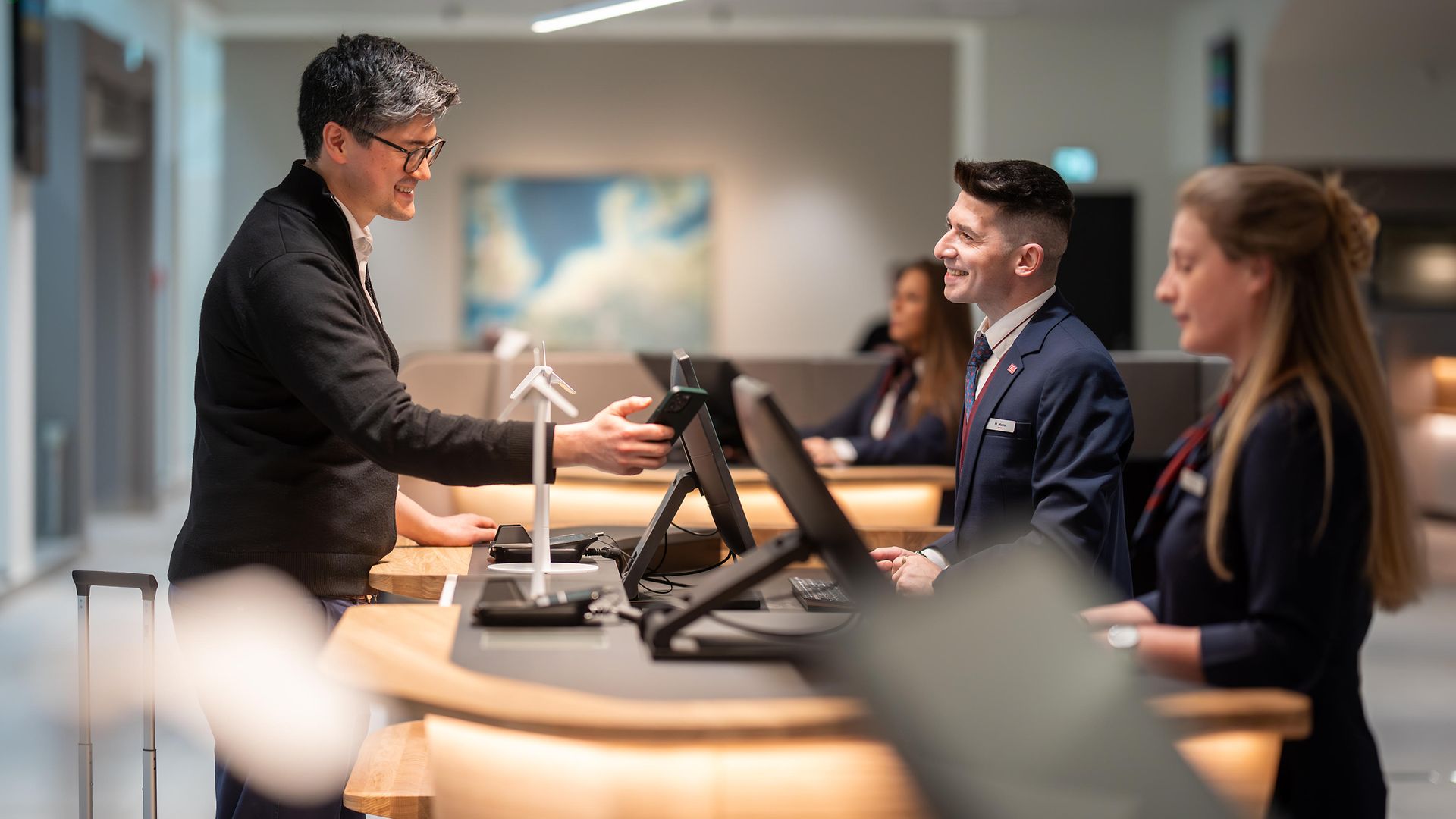 Zwei Mitarbeitende im Reisezentrum im Gespräch mit einem Kunden