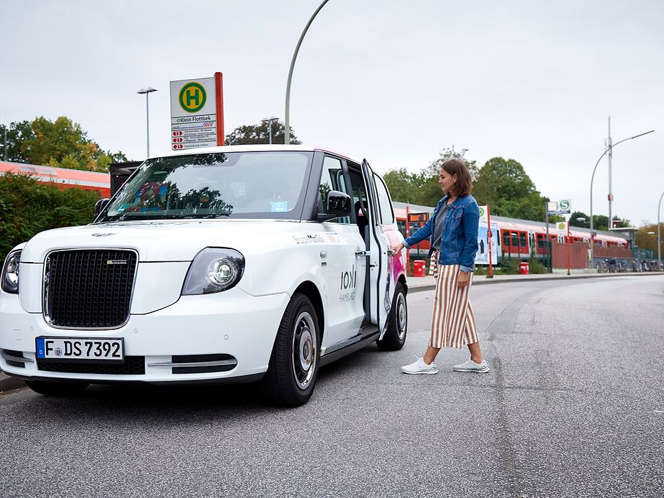 eine Frau steigt in ein Auto ein